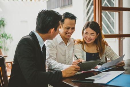 happy couple reviewing documents with a professional