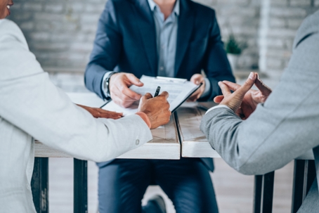 couple signing a document with a lawyer
